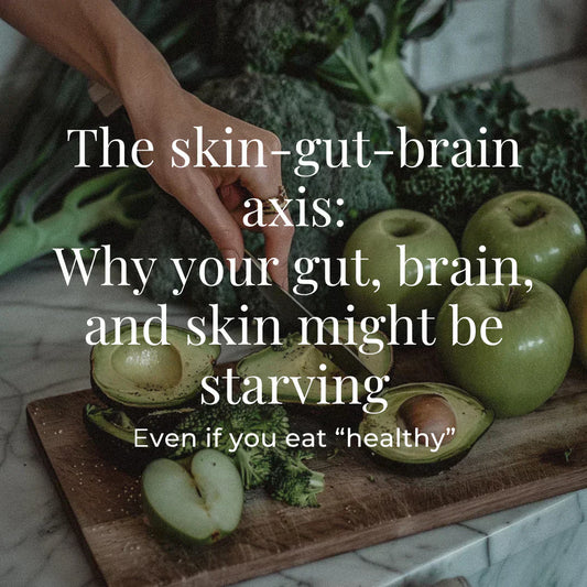 A hand slices a green avocado on a wooden board, surrounded by kale and green apples. The imagery suggests holistic nutrition. The overlaid text reads: “The skin-gut-brain axis: Why your gut, brain, and skin might be starving – Even if you eat 'healthy'.”